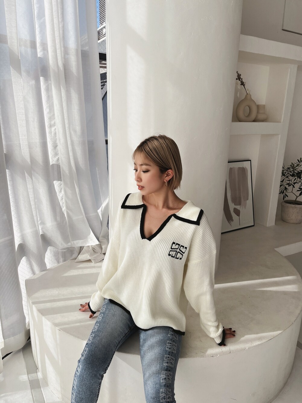 ホワイト系のニット/セーター、ホワイト系のパンプス、ブルー系のパンツを着用したレディースの冬コーディネートの2枚目の写真