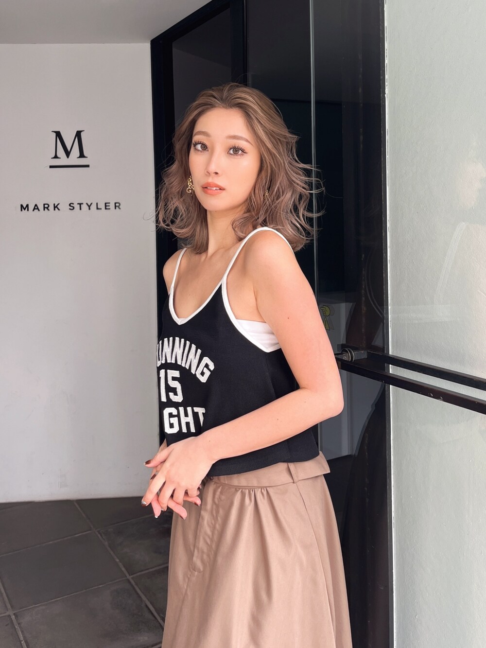 ホワイト系のキャミソール、ベージュ系のスカートを着用したレディースの夏コーディネートの3枚目の写真