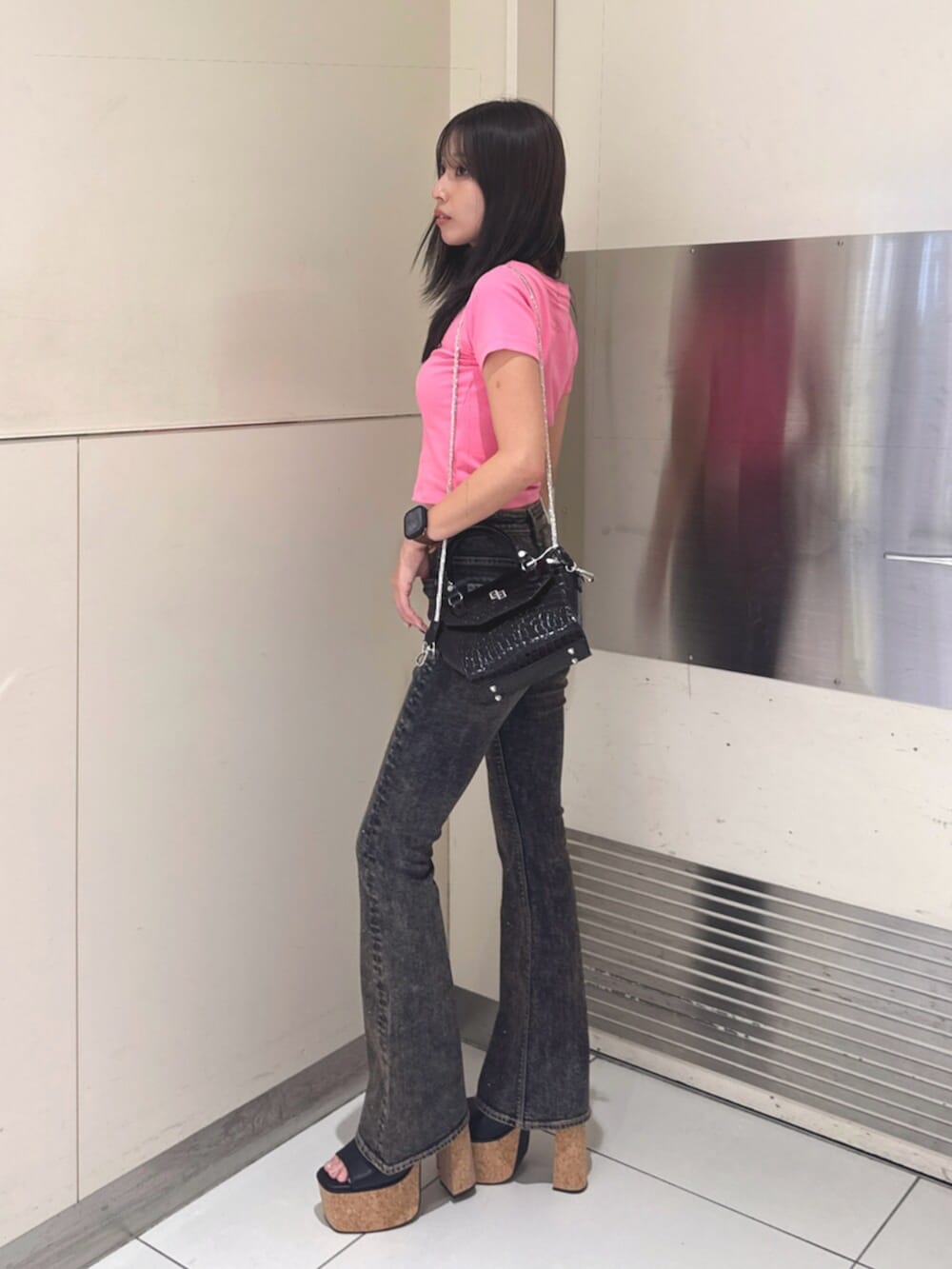 ブラック系のハンドバッグ、ブラック系のサンダル、ブルー系のデニムパンツを着用したレディースの夏コーディネートの2枚目の写真