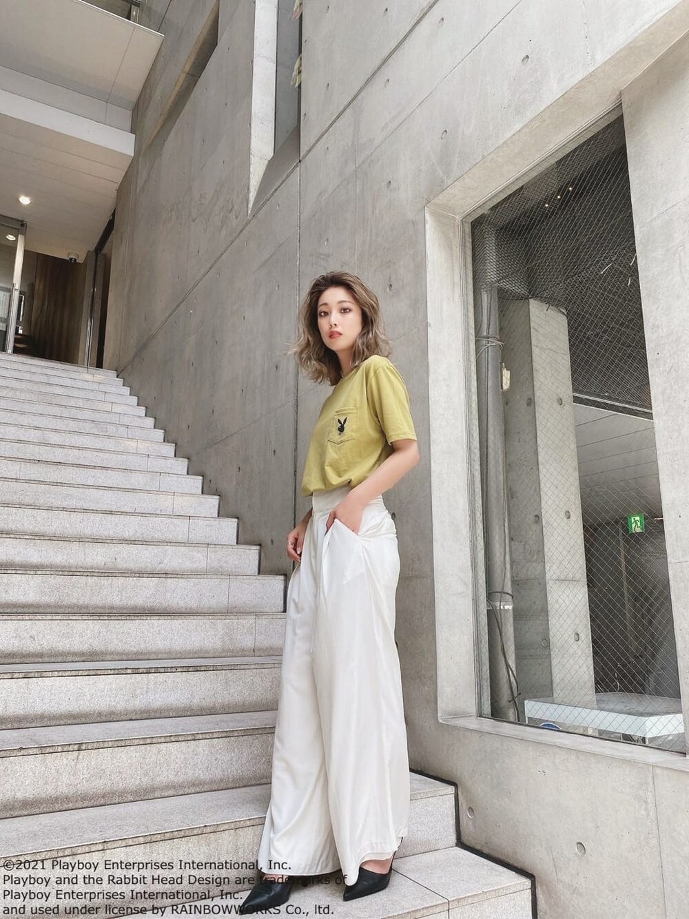 イエロー系のTシャツ/カットソー、ホワイト系のスラックス、ブラック系のパンプスを着用したレディースの夏コーディネートの3枚目の写真