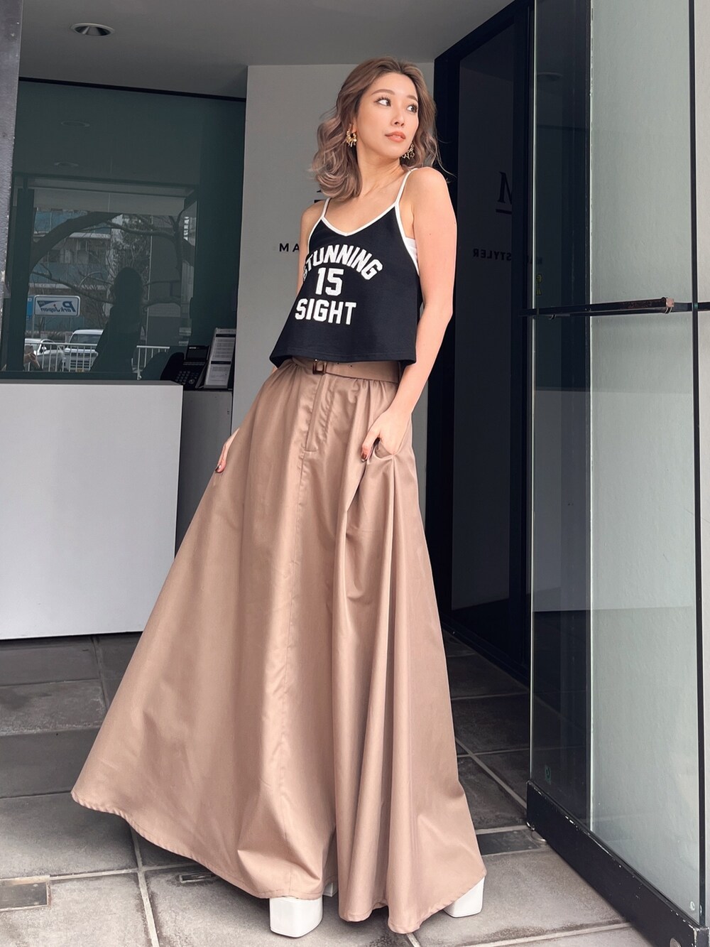 ホワイト系のキャミソール、ベージュ系のスカートを着用したレディースの夏コーディネートの2枚目の写真