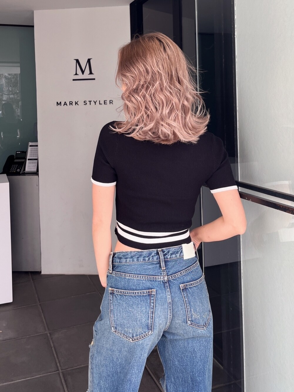 ブルー系のデニムパンツ、ブラック系のニット/セーターを着用したレディースの秋コーディネートの3枚目の写真