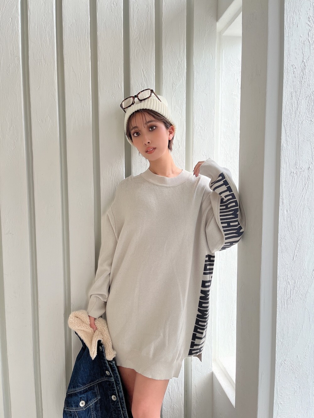 ホワイト系のニット/セーター、ブルー系のデニムジャケット、ブラック系のブーツを着用したレディースの秋コーディネートの6枚目の写真