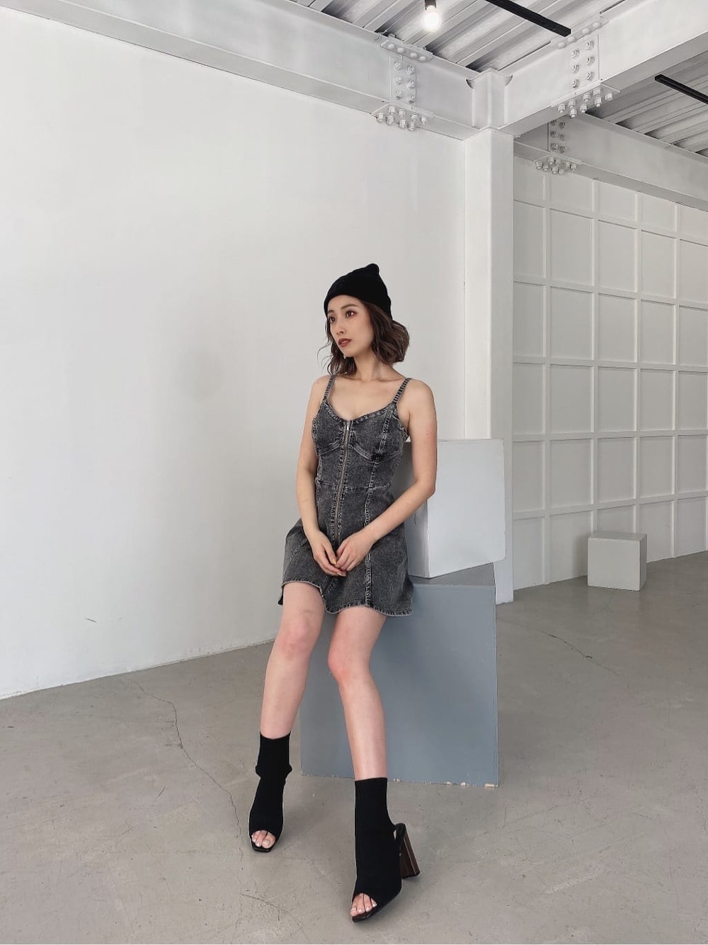 ブラック系のワンピース、ブラック系のブーツ、ブラック系のニットキャップ/ビーニーを着用したレディースの夏コーディネートの2枚目の写真