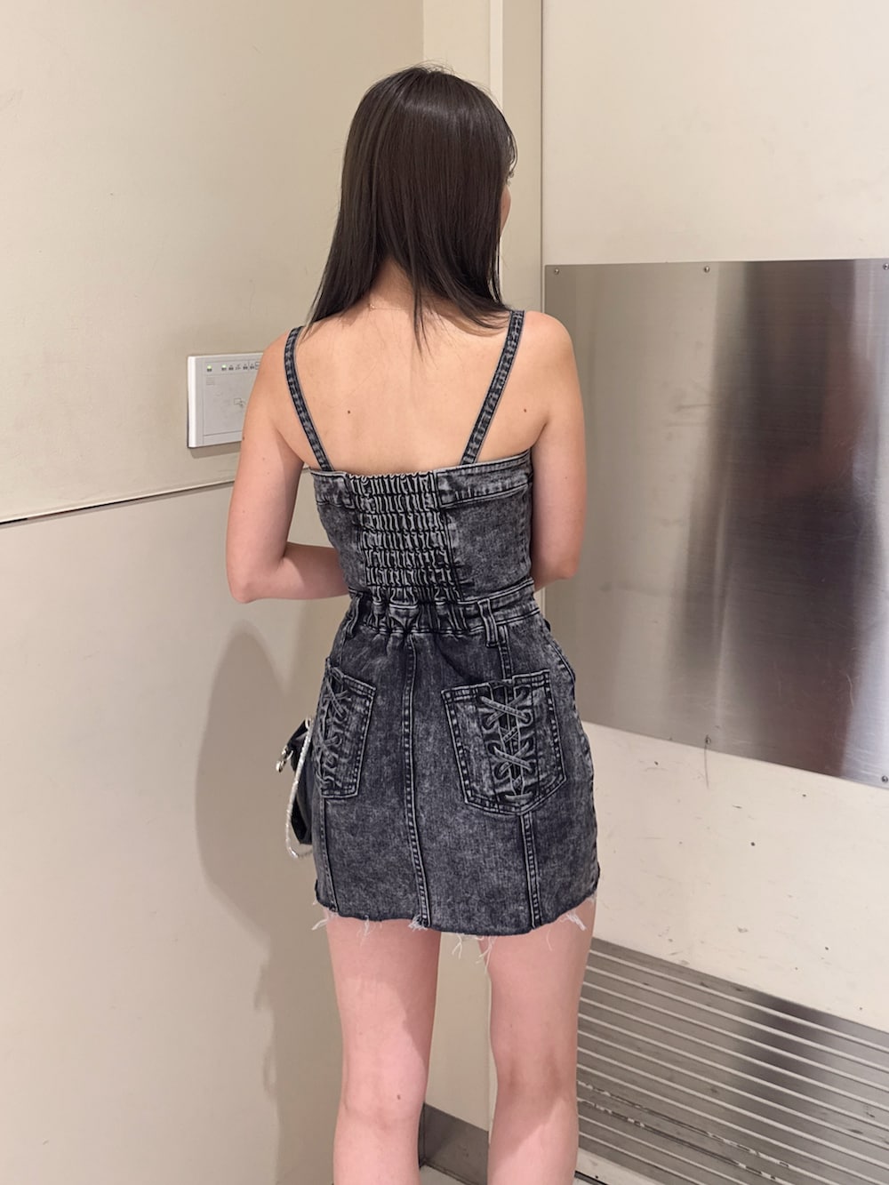 ブラック系のハンドバッグ、ブラック系のサンダル、ブラック系のワンピースを着用したレディースの夏コーディネートの5枚目の写真
