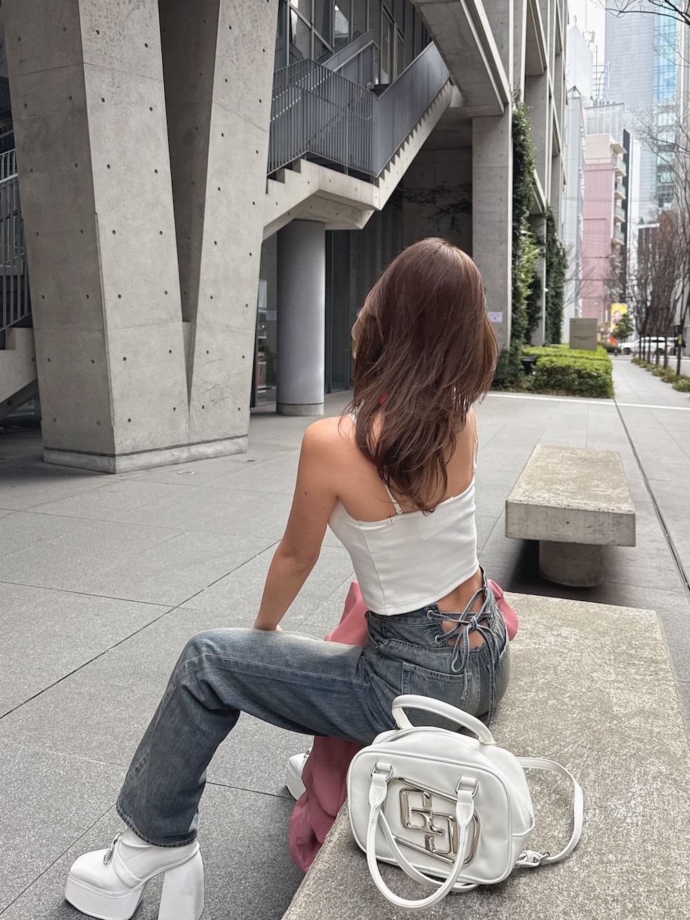 ホワイト系のキャミソール、ブルー系のデニムパンツを着用したレディースの春コーディネートの3枚目の写真