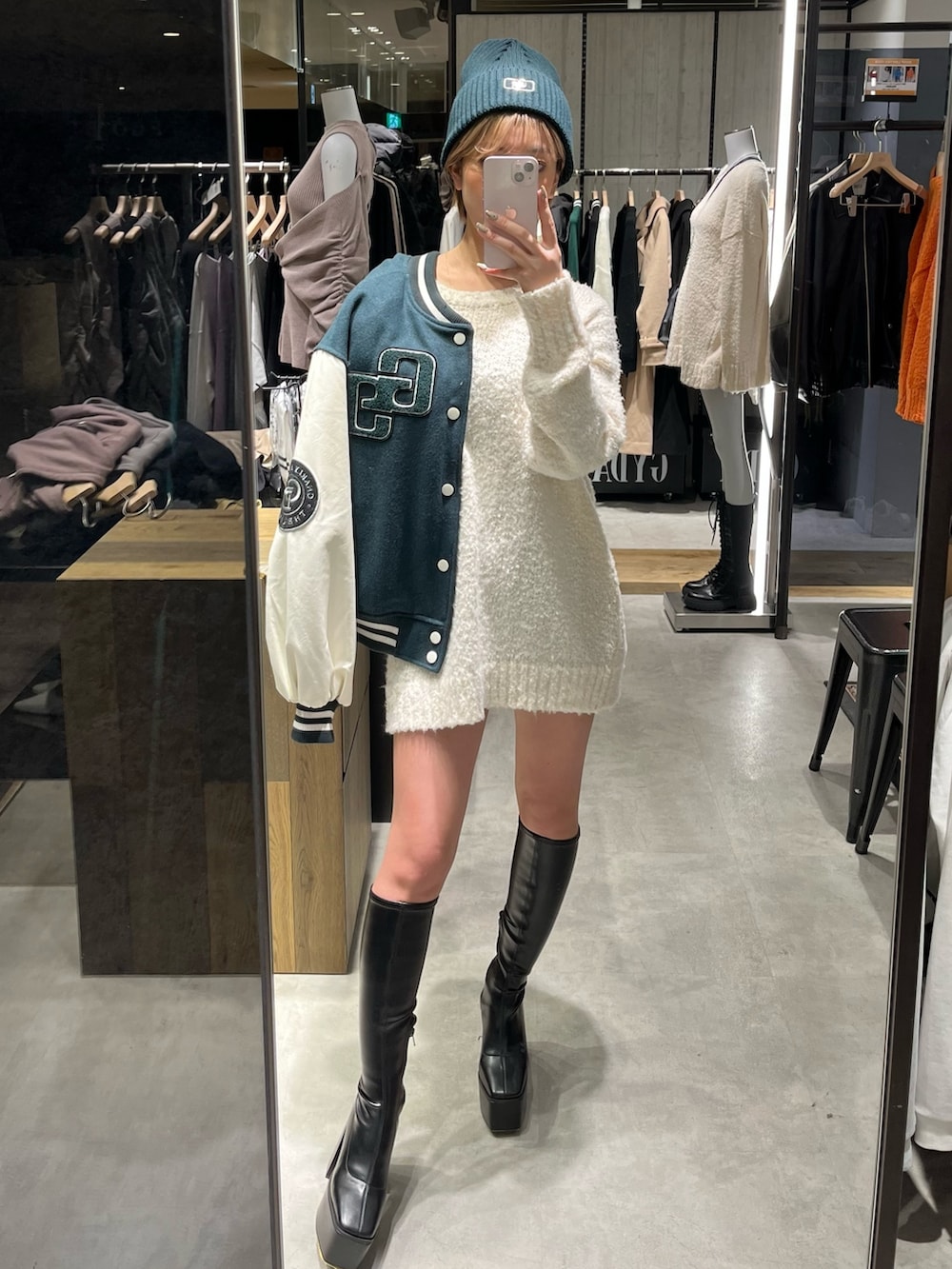 ブラック系のショルダーバッグ、ブラック系のブーツ、ホワイト系のニット/セーターを着用したレディースの冬コーディネートの4枚目の写真