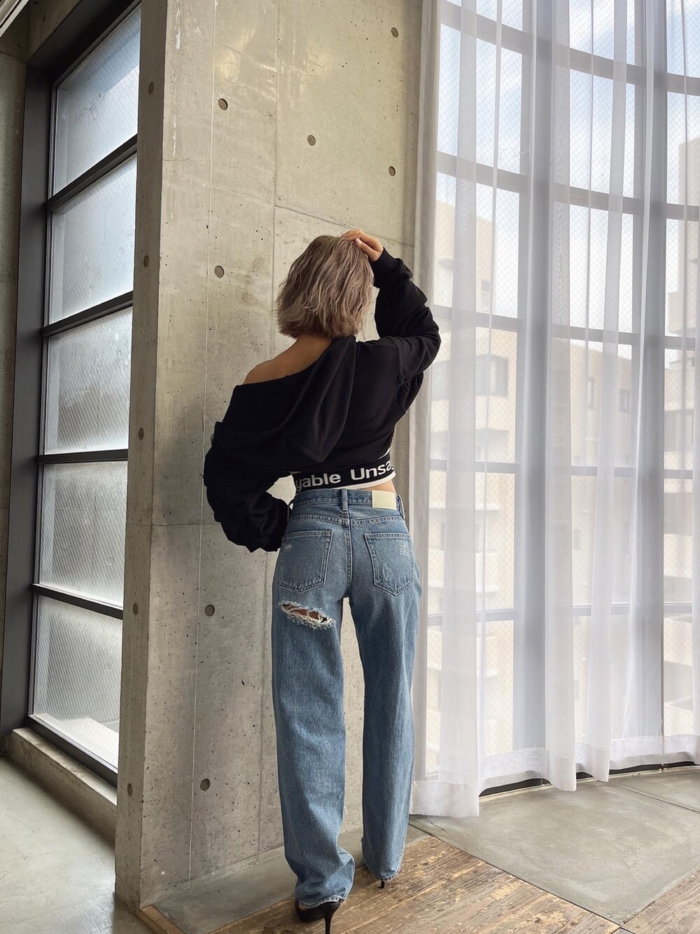 ブルー系のデニムパンツ、ブラック系のパーカーを着用したレディースの夏コーディネートの3枚目の写真