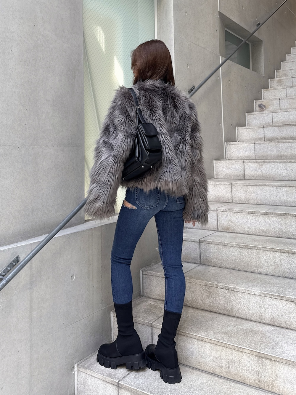 グレー系のライダースジャケットを着用したレディースの秋コーディネートの2枚目の写真