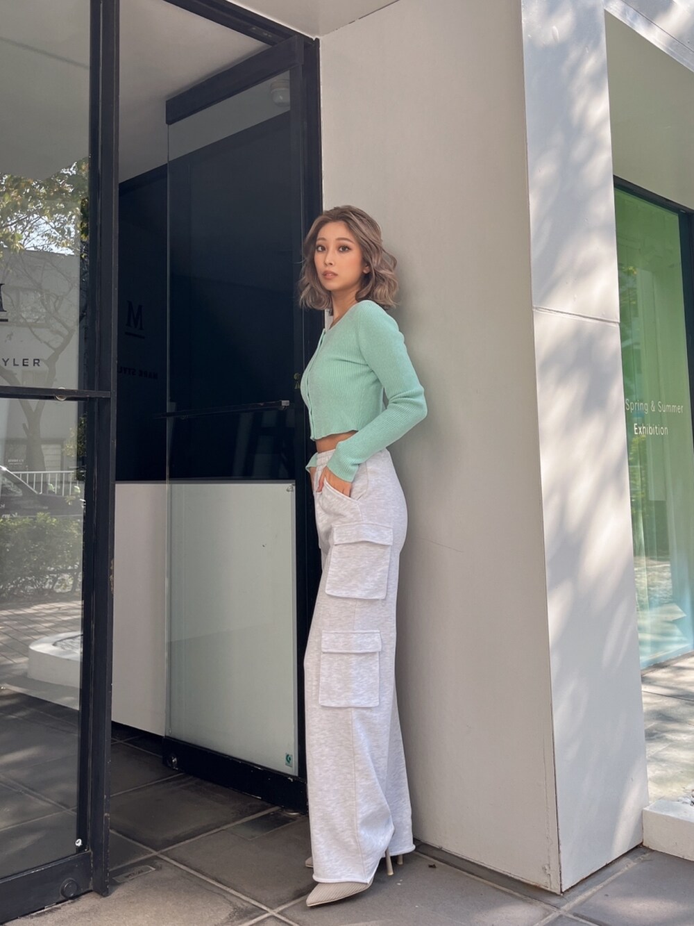 グレー系のカーゴパンツ、グリーン系のカーディガン/ボレロ、ベージュ系のパンプスを着用したレディースの冬コーディネートの3枚目の写真