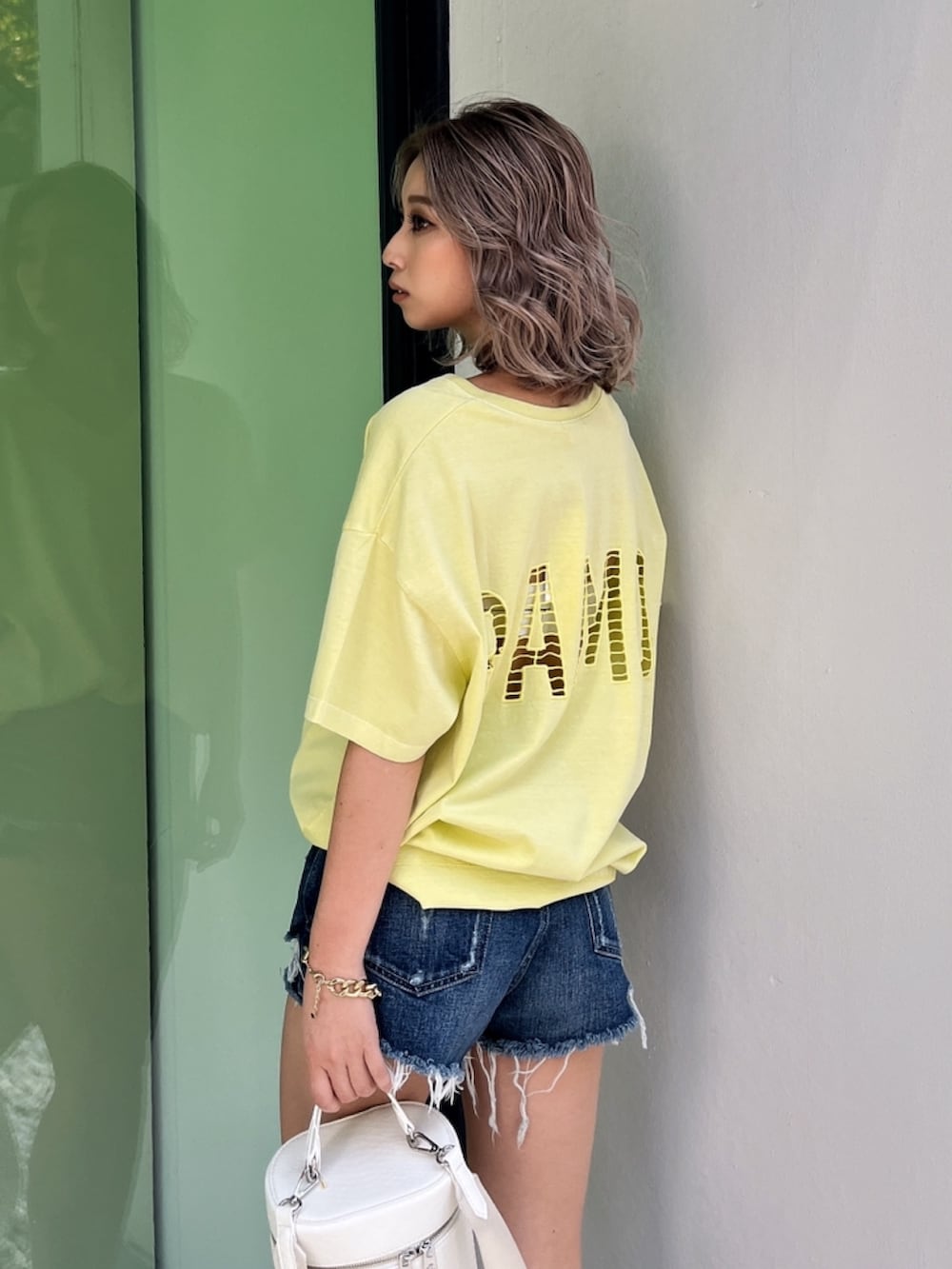 イエロー系のTシャツ/カットソー、ブルー系のデニムパンツ、ベージュ系のサンダルを着用したレディースの夏コーディネートの4枚目の写真