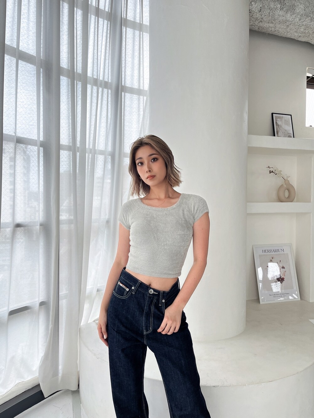 ブルー系のデニムパンツを着用したレディースの秋コーディネートの2枚目の写真