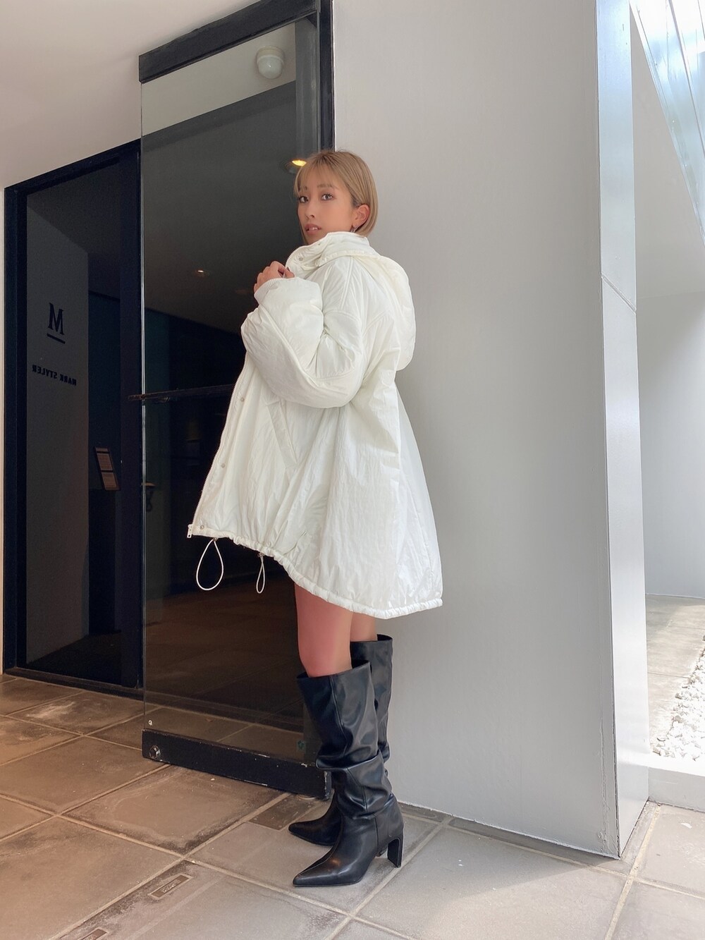 ホワイト系のブルゾンを着用したレディースの冬コーディネートの2枚目の写真