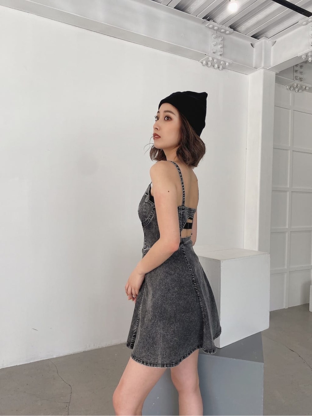 ブラック系のワンピース、ブラック系のブーツ、ブラック系のニットキャップ/ビーニーを着用したレディースの夏コーディネートの3枚目の写真