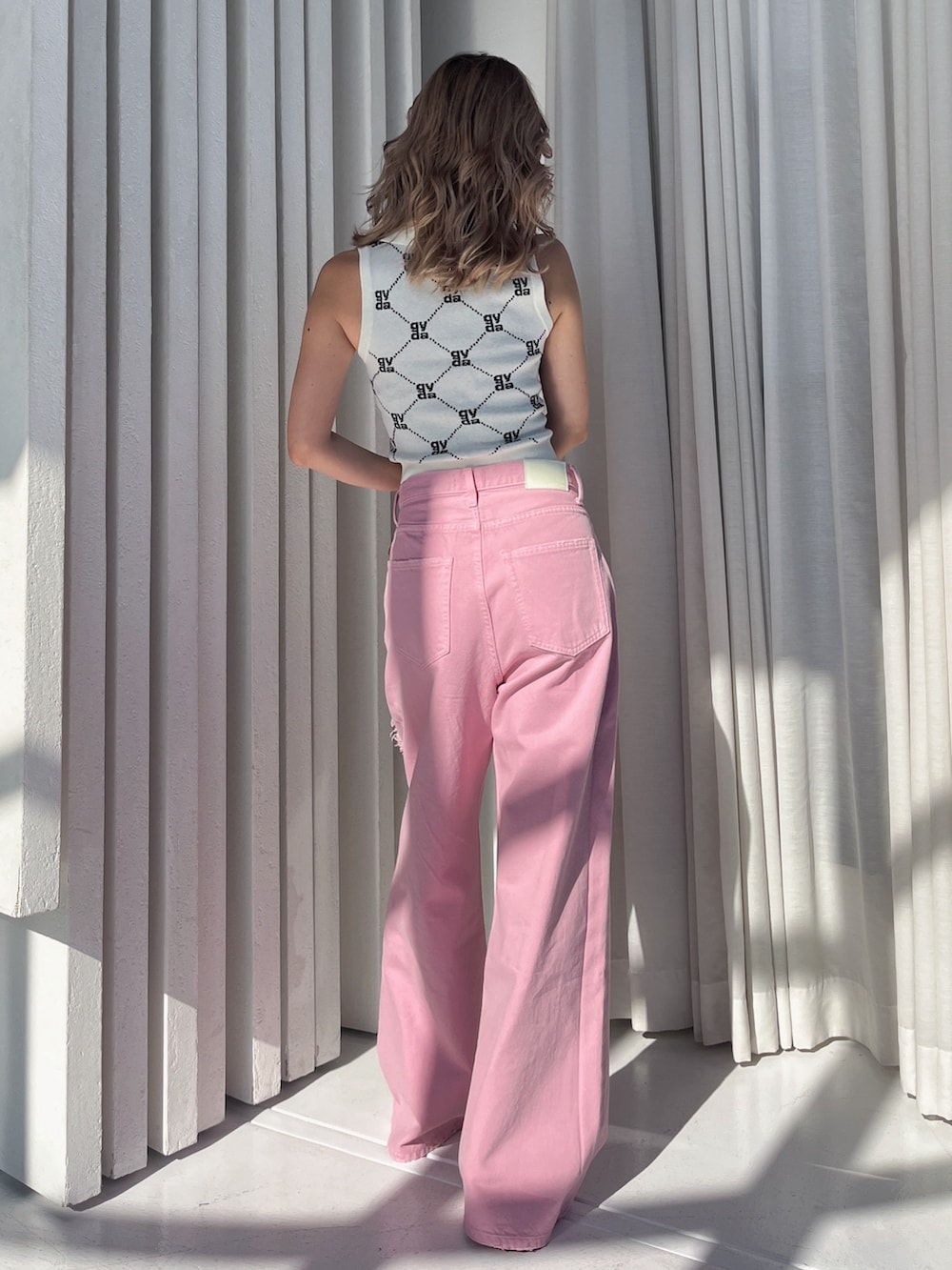 ホワイト系のニット/セーターを着用したレディースの夏コーディネートの2枚目の写真