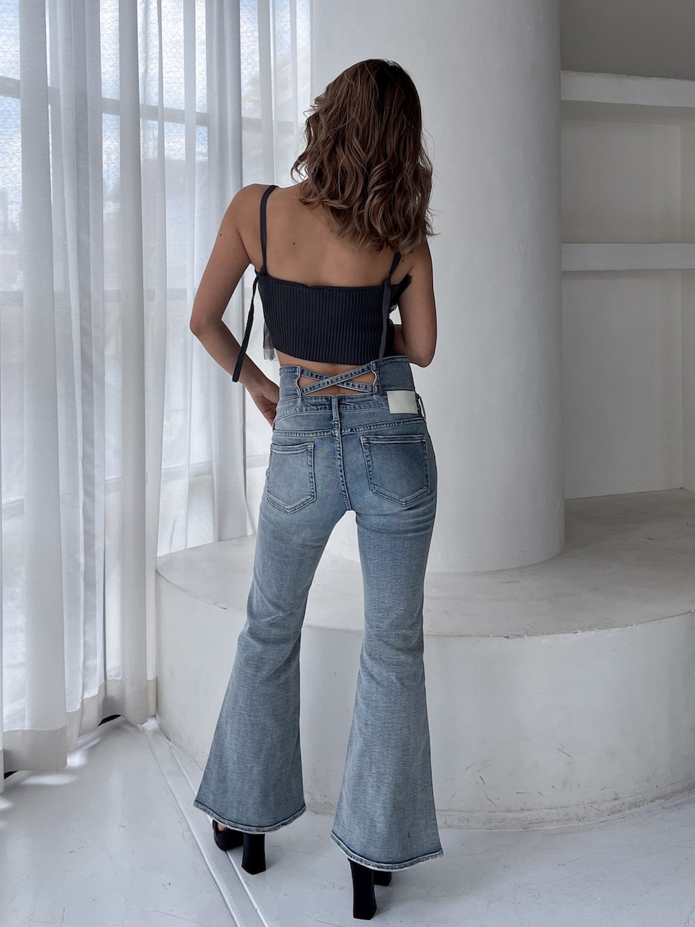 グレー系のキャミソール、ブルー系のデニムパンツ、ブラック系のサンダルを着用したレディースの夏コーディネートの2枚目の写真