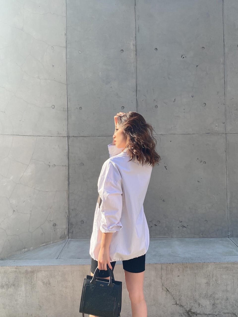 ホワイト系のブルゾン、ブラック系のレギンス/スパッツを着用したレディースの春コーディネートの3枚目の写真