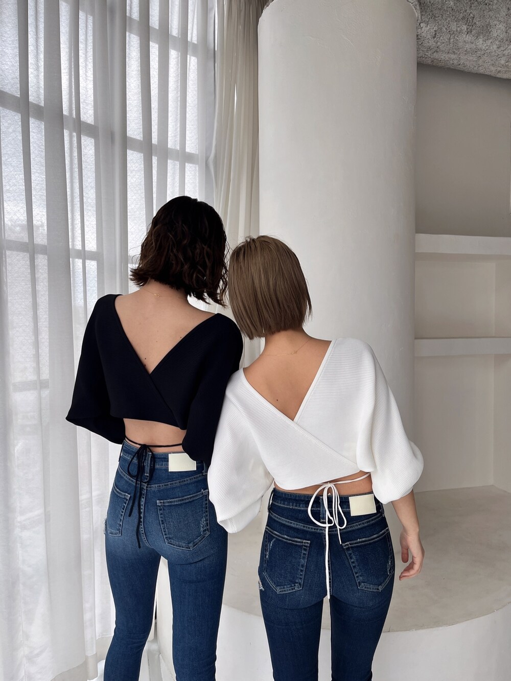 ホワイト系のニット/セーター、ブルー系のデニムパンツを着用したレディースの冬コーディネートの2枚目の写真