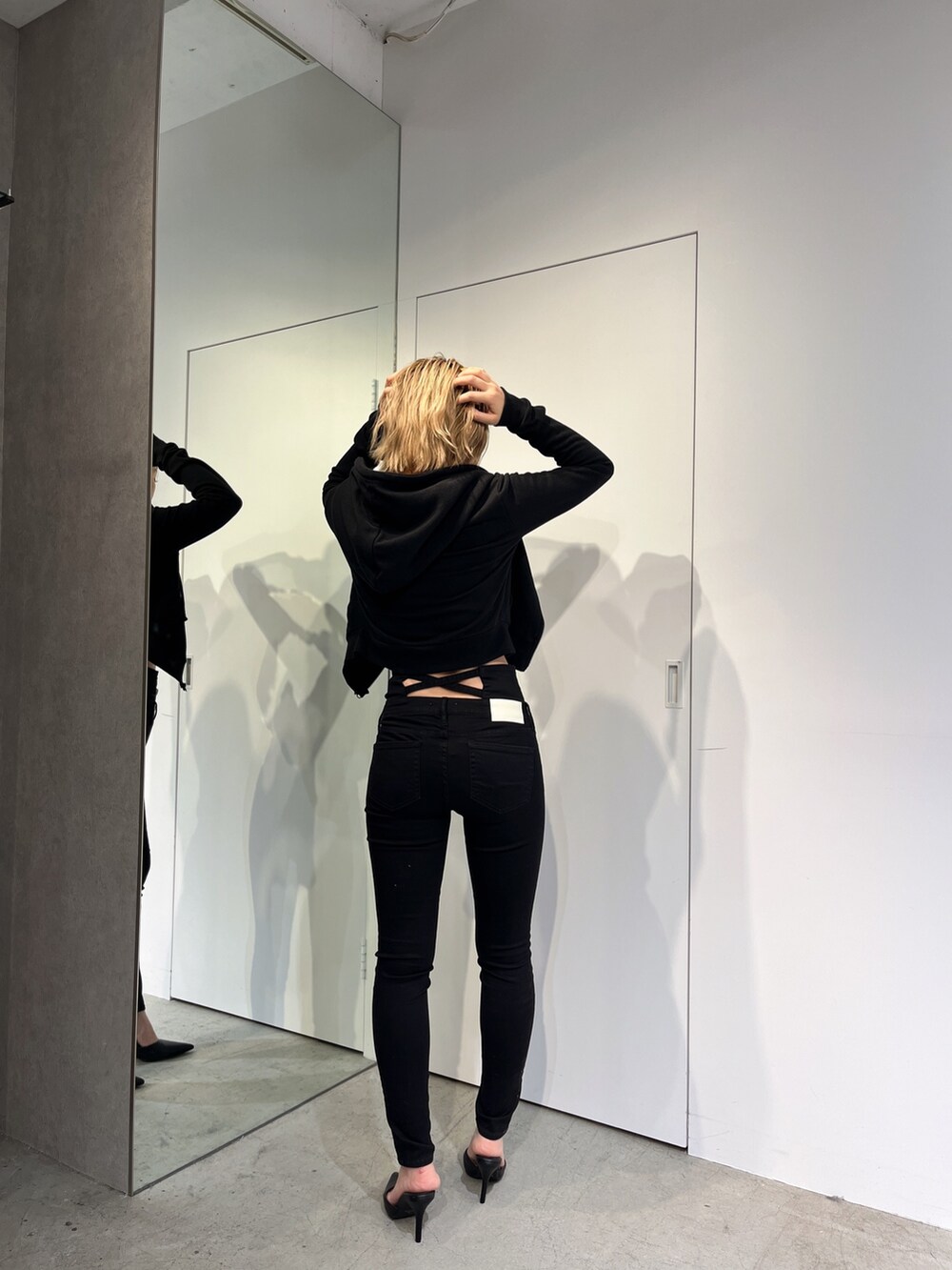 ブラック系のデニムパンツ、ブラック系のパーカー、ブラック系のキャミソールを着用したレディースの春コーディネートの5枚目の写真