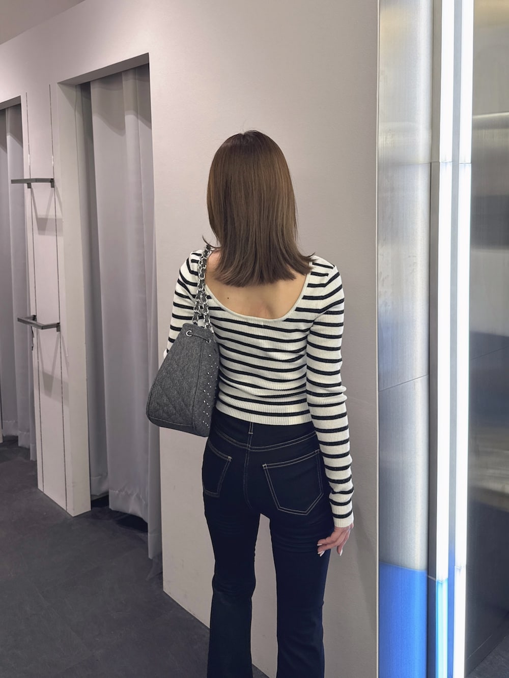 ブラック系のデニムパンツ、ブラック系のブーツ、その他のニット/セーターを着用したレディースの秋コーディネートの6枚目の写真