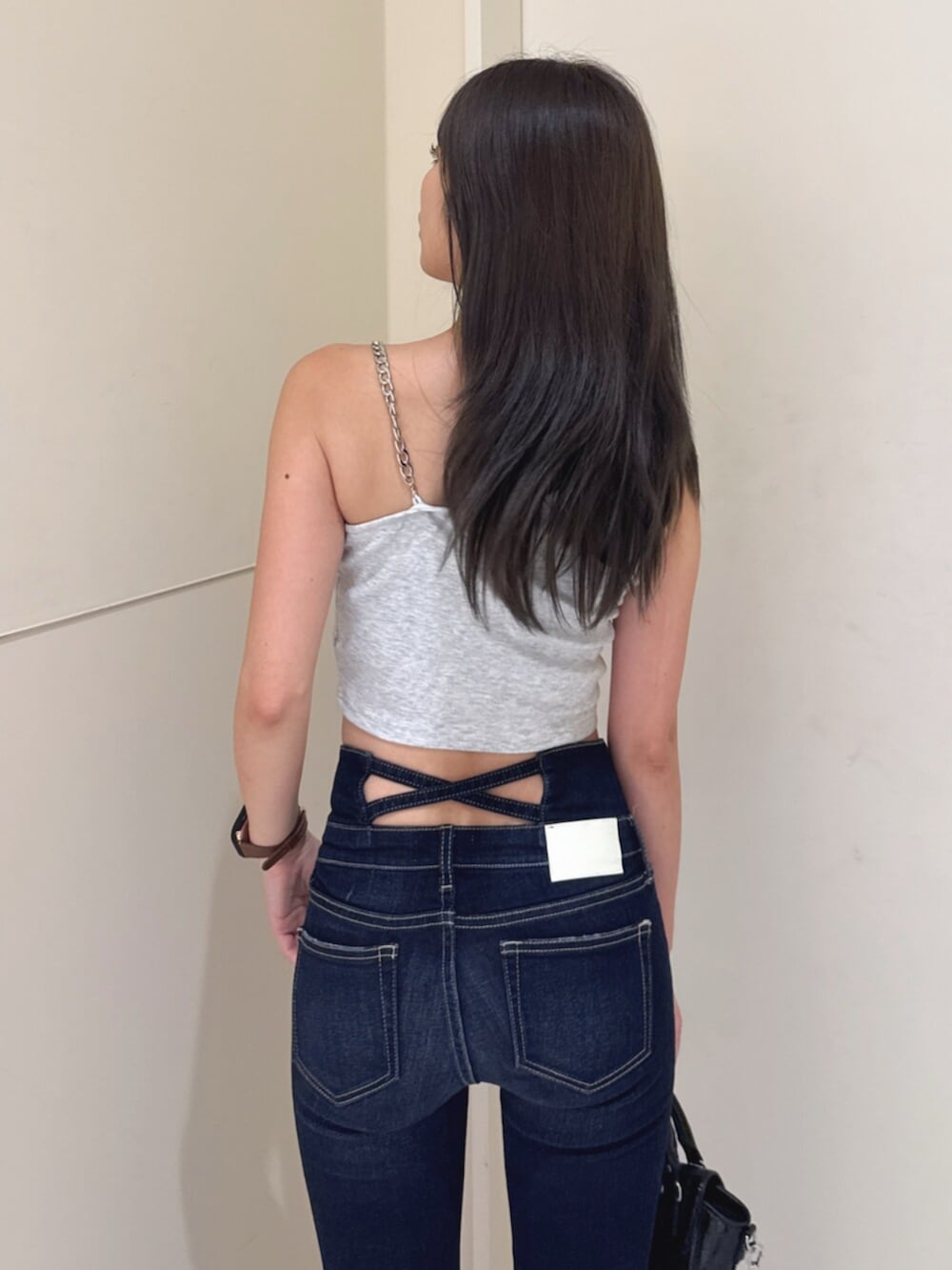 ブルー系のデニムパンツ、グレー系のタンクトップ、ブラック系のサンダルを着用したレディースの夏コーディネートの6枚目の写真