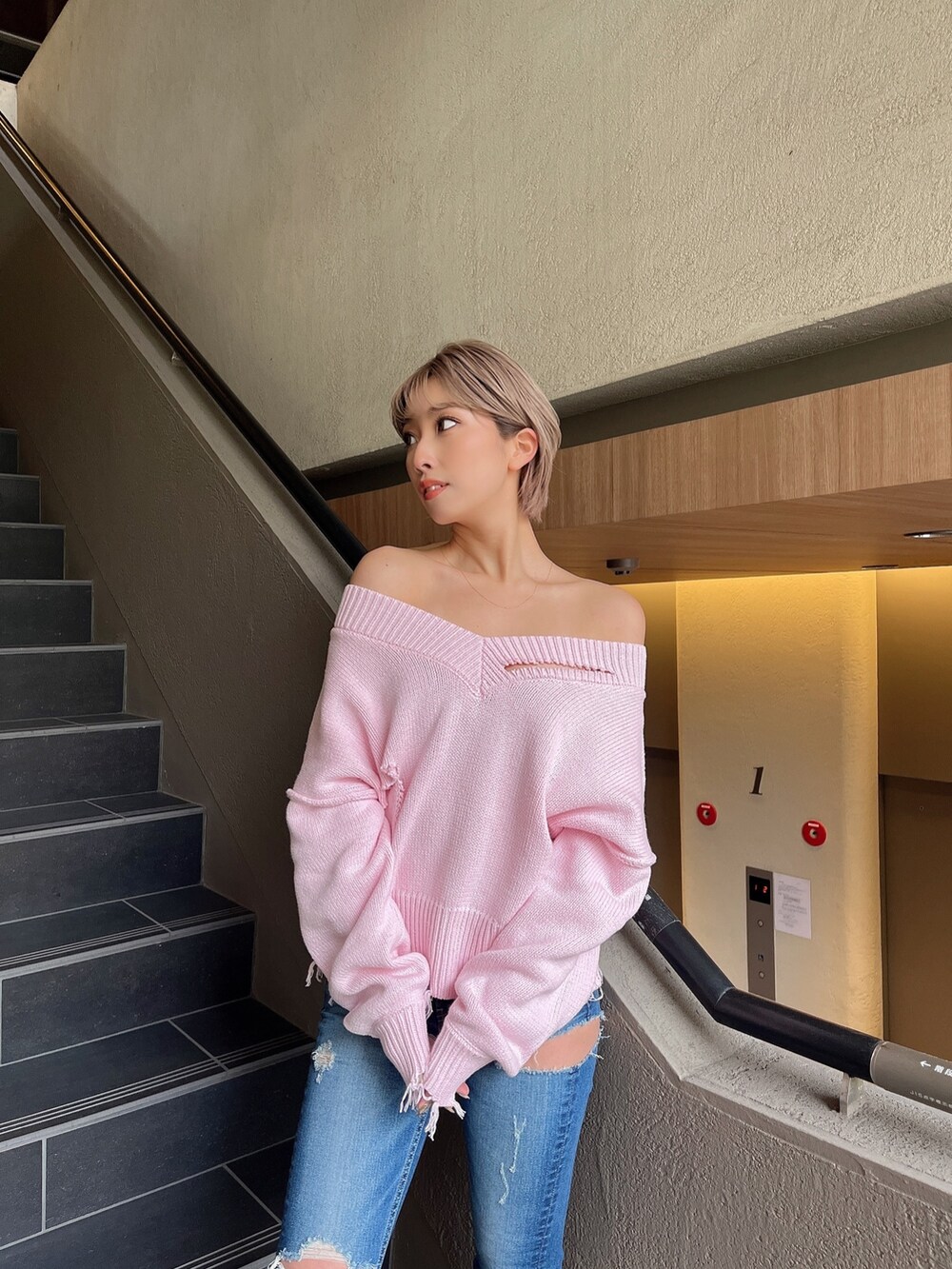 ピンク系のニット/セーター、ブルー系のデニムパンツ、ホワイト系のブーツを着用したレディースの冬コーディネートの4枚目の写真