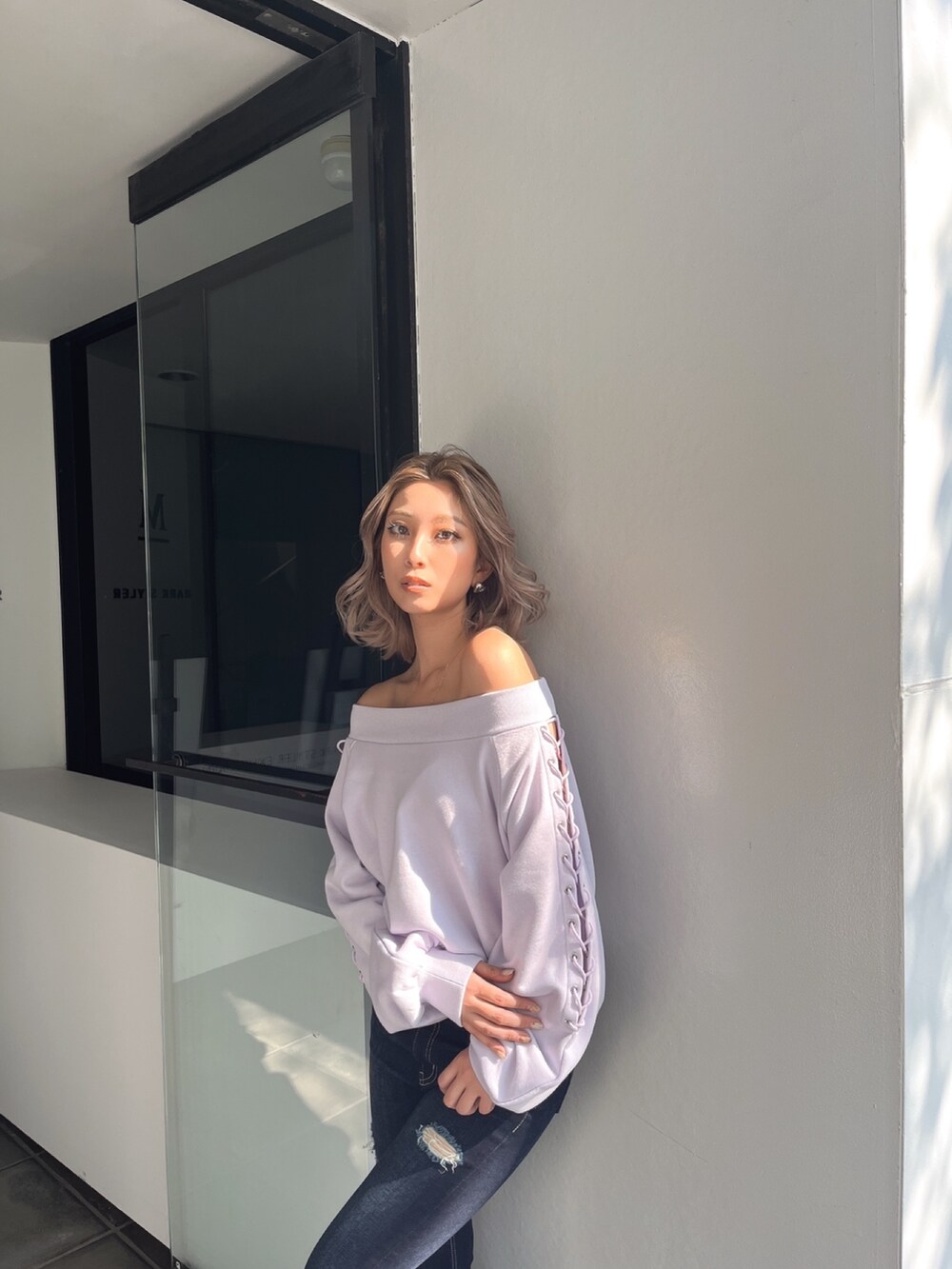 パープル系のスウェット、ブルー系のデニムパンツを着用したレディースの春コーディネートの4枚目の写真