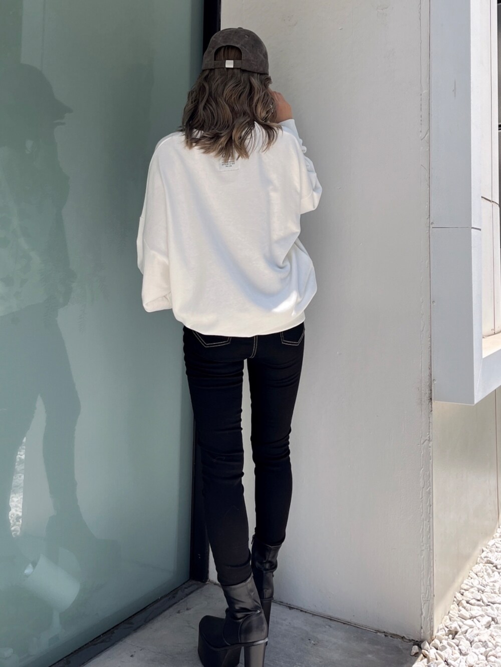 ホワイト系のスウェット、ブラック系のデニムパンツ、ホワイト系のブーツを着用したレディースの冬コーディネートの3枚目の写真