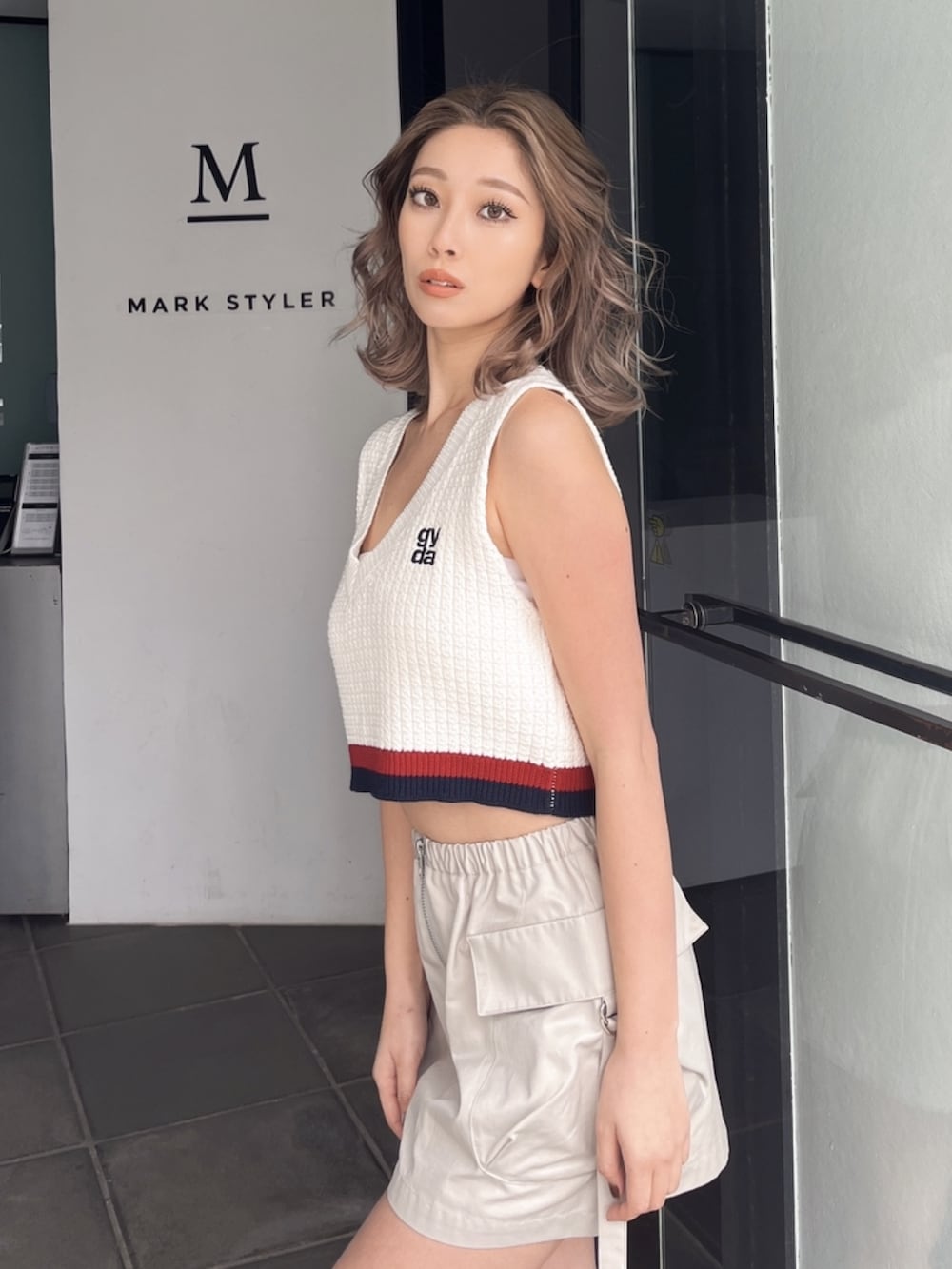 ホワイト系のニット/セーター、ホワイト系のカーゴパンツ、ブラック系のサンダルを着用したレディースの秋コーディネートの6枚目の写真