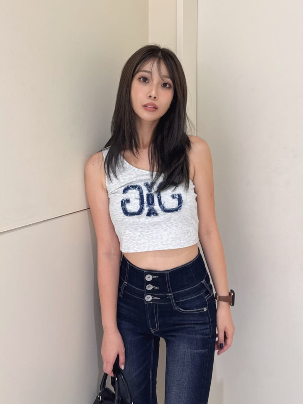 ブルー系のデニムパンツ、グレー系のタンクトップ、ブラック系のサンダルを着用したレディースの夏コーディネートの5枚目の写真
