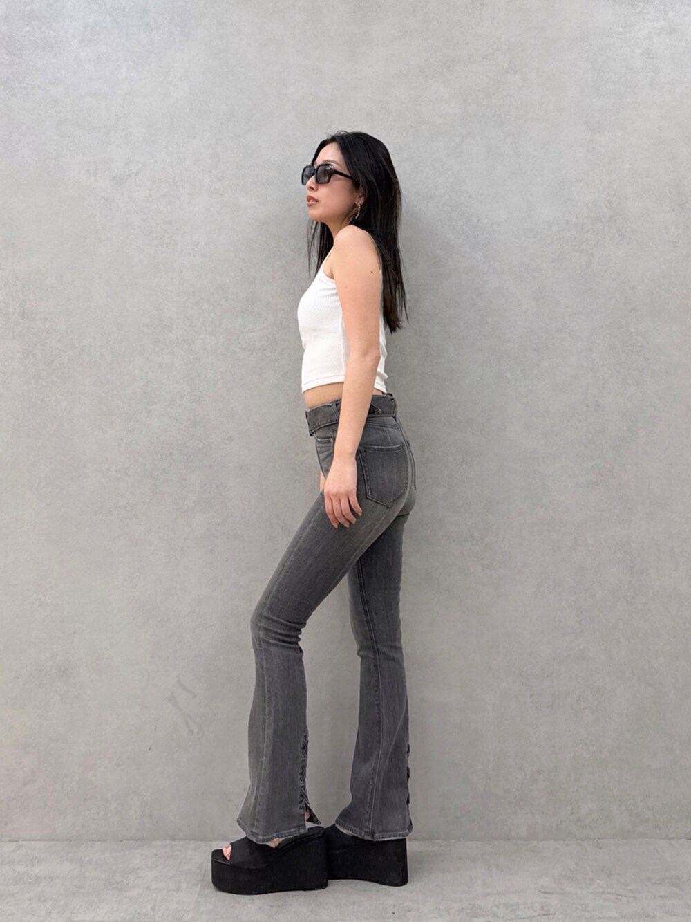 ブラック系のデニムパンツ、ホワイト系のタンクトップを着用したレディースの夏コーディネートの2枚目の写真