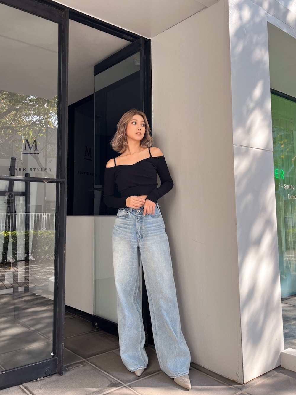 ブルー系のデニムパンツ、ブラック系のTシャツ/カットソー、ベージュ系のパンプスを着用したレディースの春コーディネートの2枚目の写真