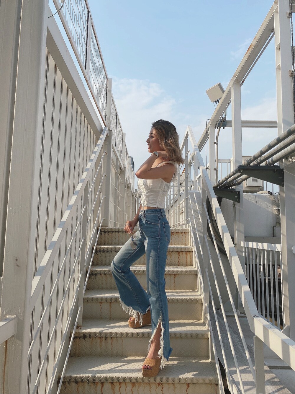 ベージュ系のサンダル、ブルー系のデニムパンツ、ホワイト系のシャツ/ブラウスを着用したレディースの夏コーディネートの3枚目の写真