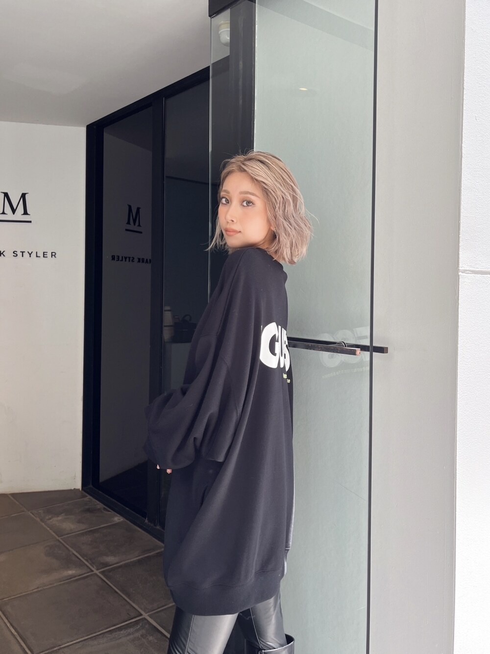 ブラック系のスウェット、ブラック系のブーツを着用したレディースの冬コーディネートの4枚目の写真