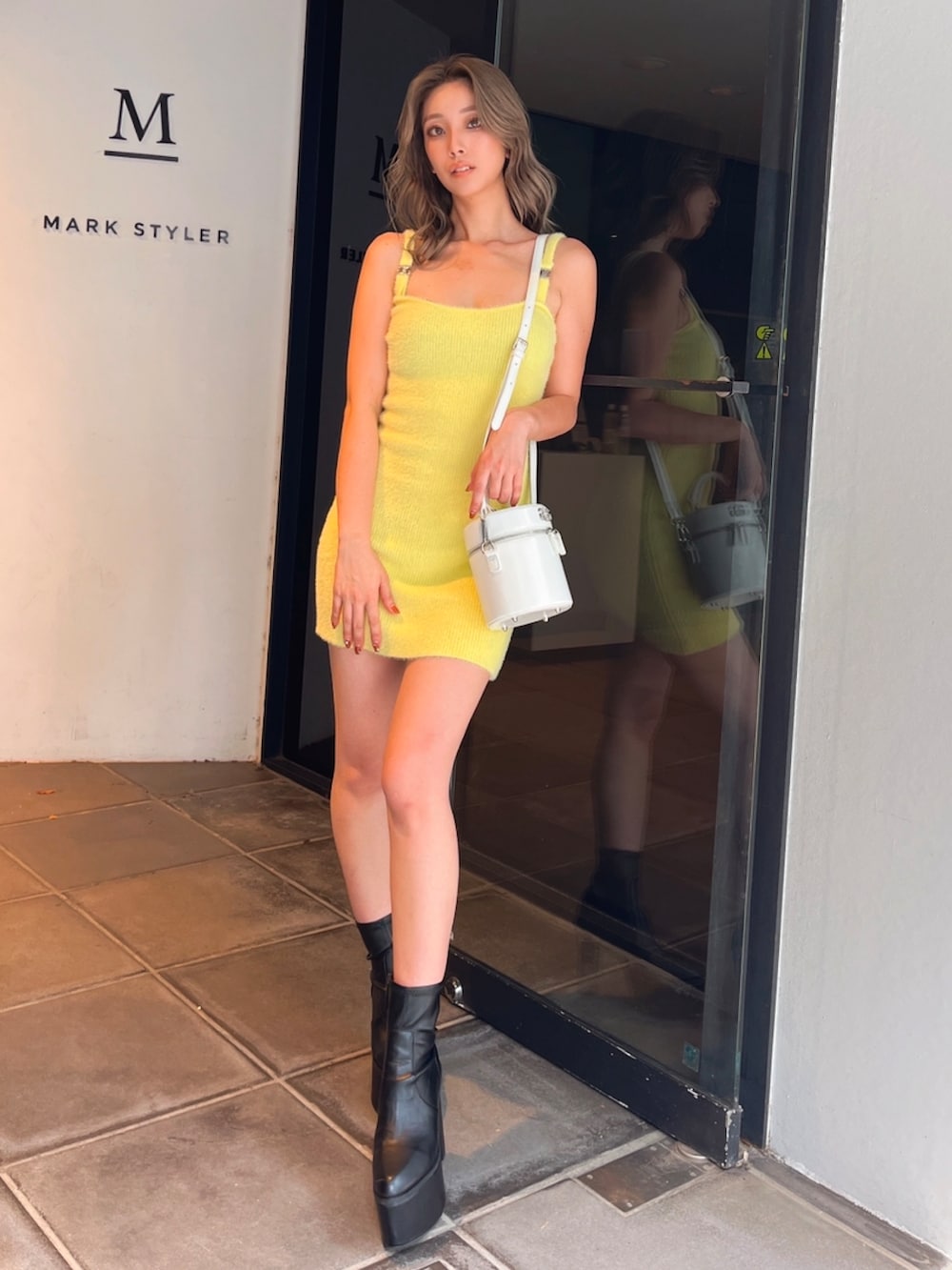 イエロー系のワンピースを着用したレディースの冬コーディネートの2枚目の写真