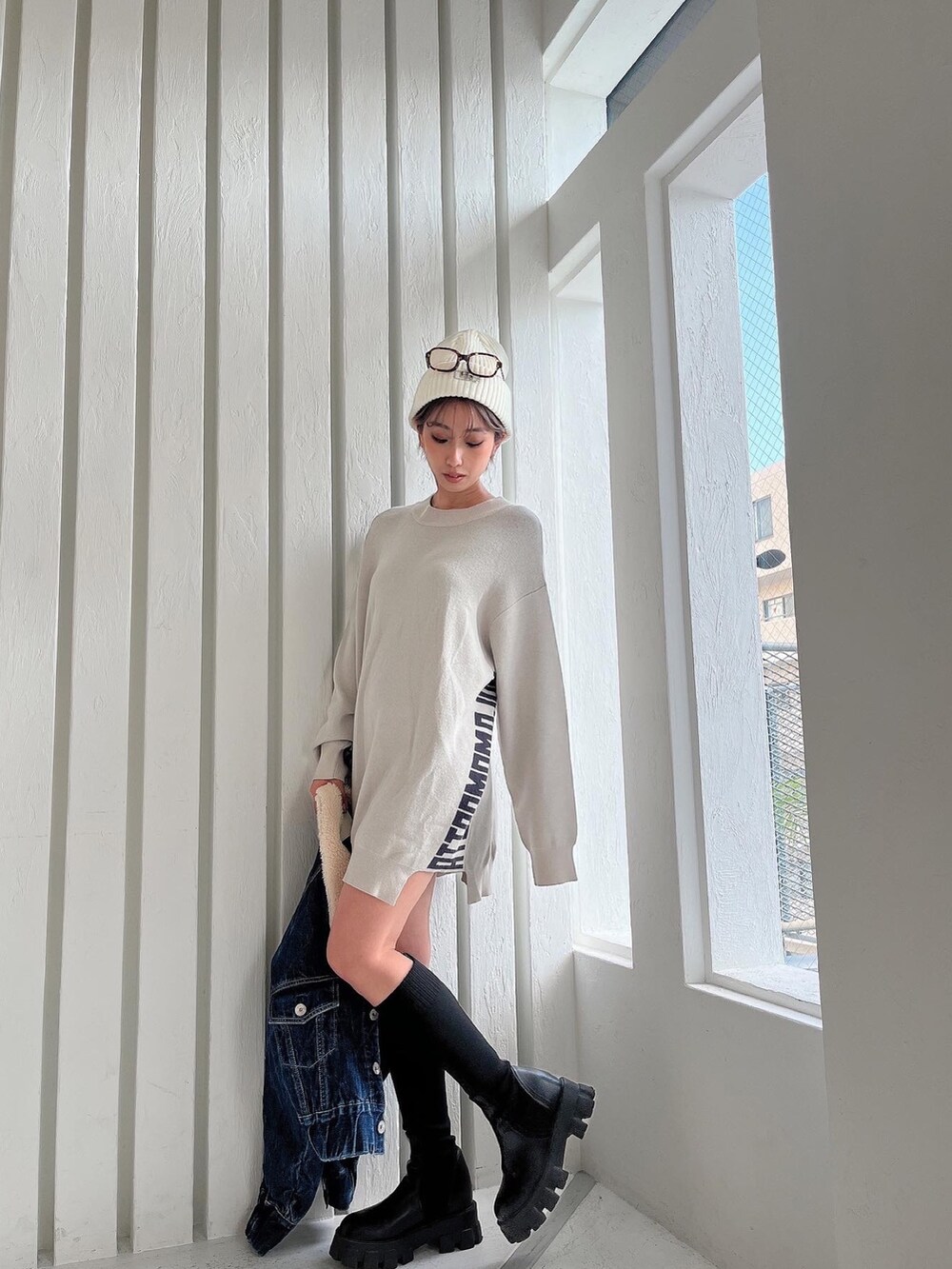 ホワイト系のニット/セーター、ブルー系のデニムジャケット、ブラック系のブーツを着用したレディースの秋コーディネートの3枚目の写真