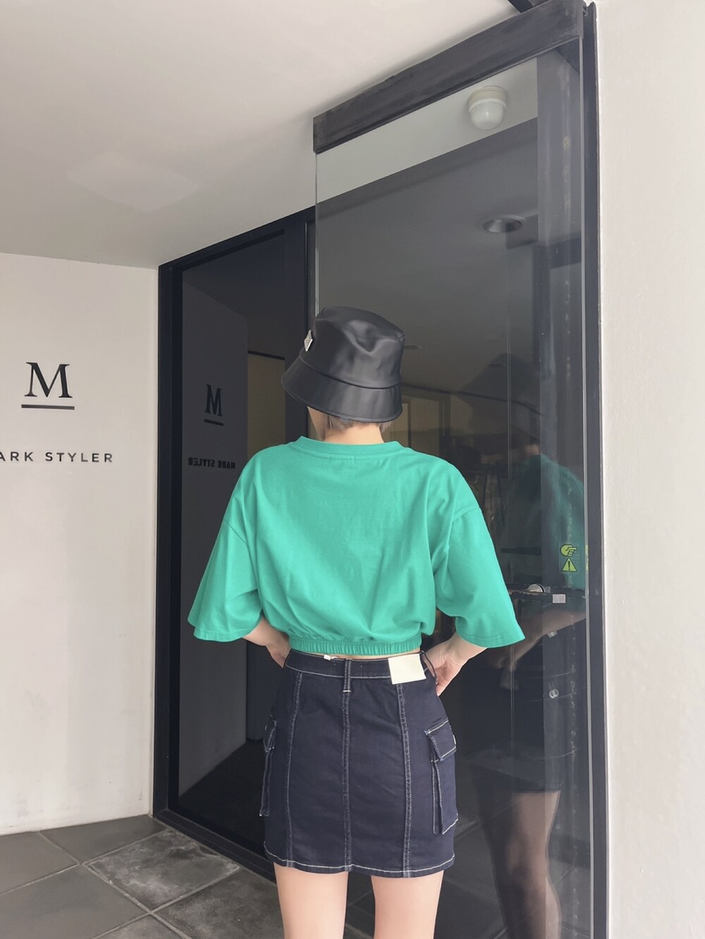 グリーン系のTシャツ/カットソー、ブルー系のデニムスカートを着用したレディースの夏コーディネートの2枚目の写真