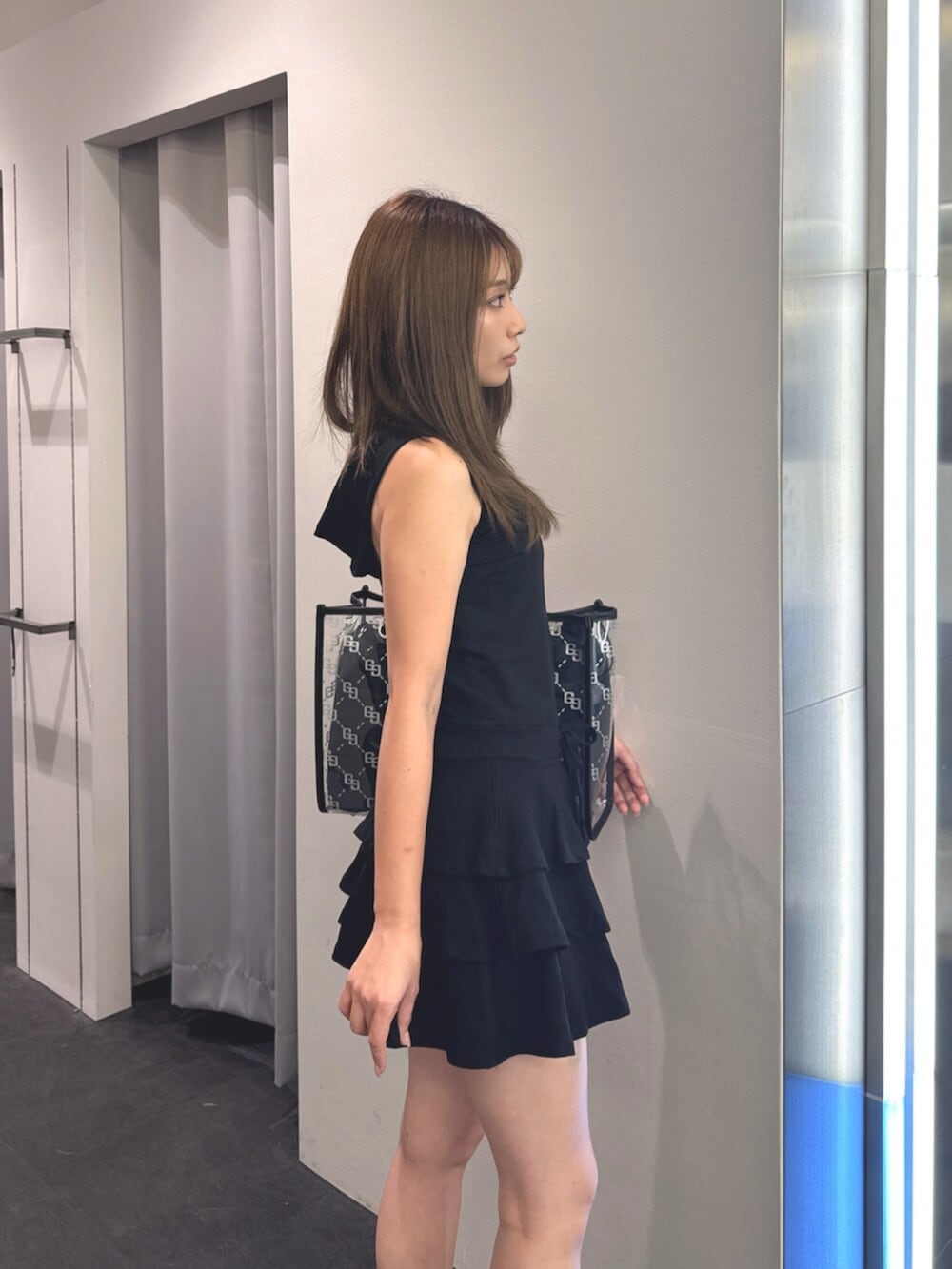ブラック系のサンダル、ブラック系のトートバッグ、ブラック系のワンピースを着用したレディースの夏コーディネートの5枚目の写真