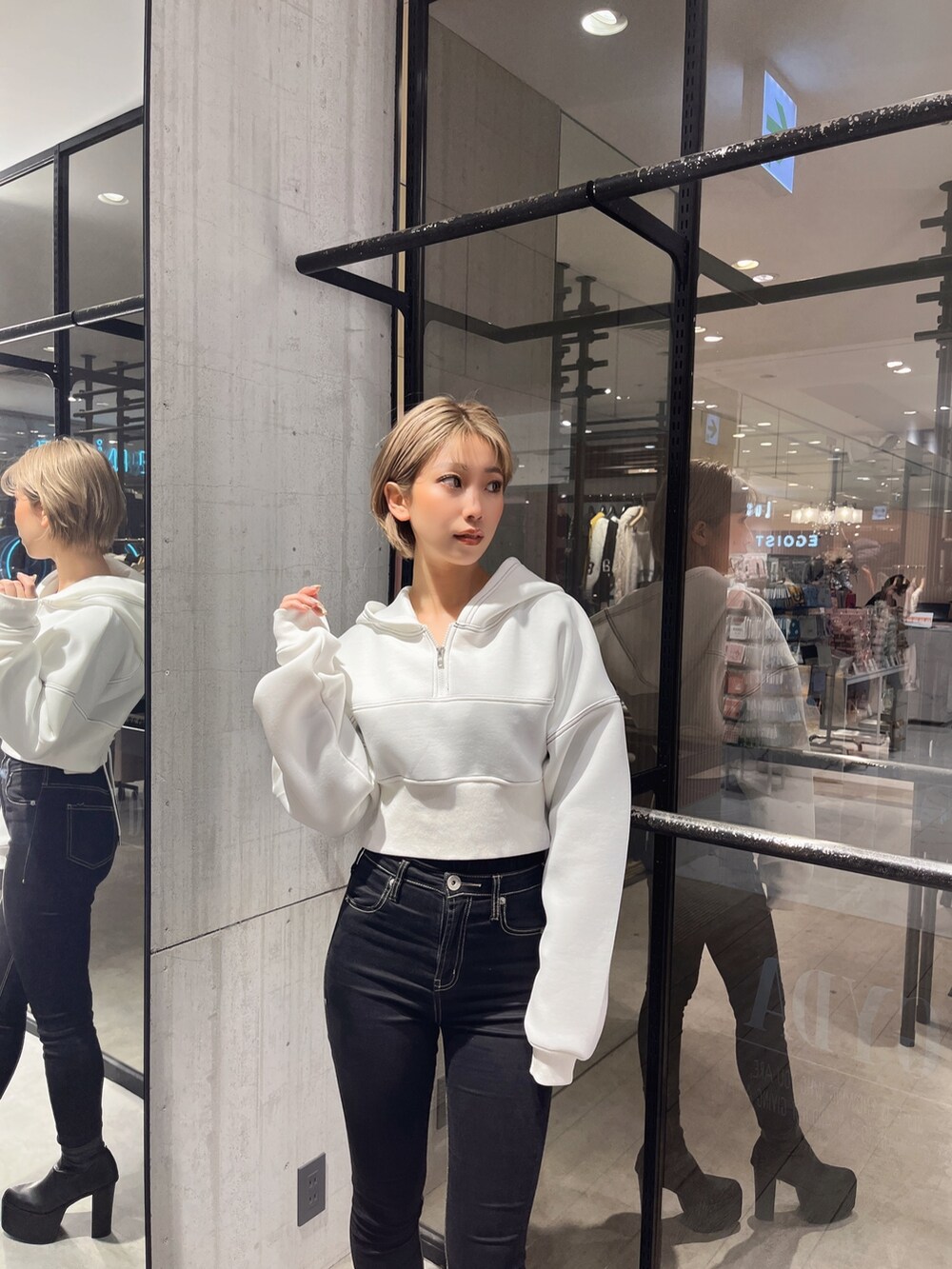 ブラック系のデニムパンツ、ホワイト系のパーカーを着用したレディースの冬コーディネートの3枚目の写真