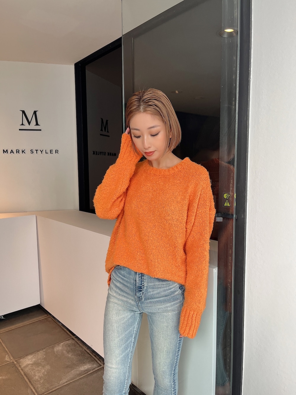 ブルー系のデニムパンツ、ホワイト系のパンプスを着用したレディースの冬コーディネートの2枚目の写真