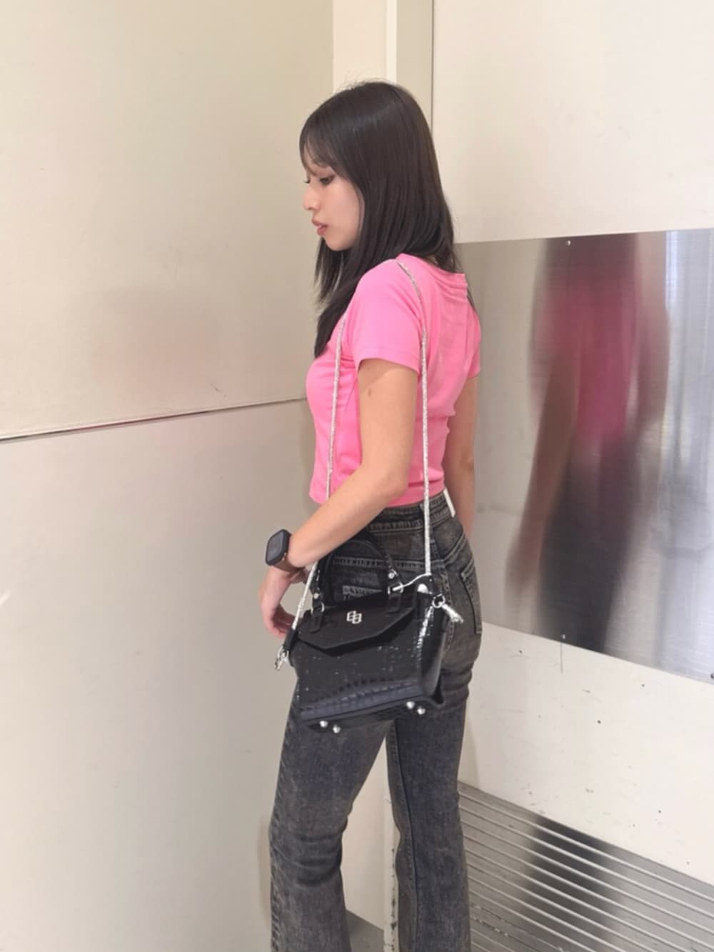 ブラック系のハンドバッグ、ブラック系のサンダル、ブルー系のデニムパンツを着用したレディースの夏コーディネートの5枚目の写真