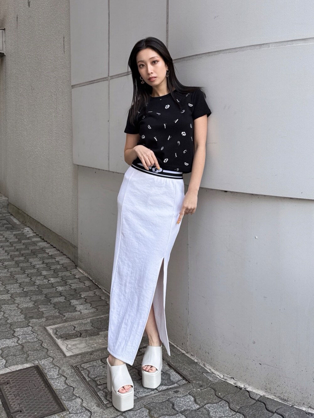 ブラック系のTシャツ/カットソー、ホワイト系のスカートを着用したレディースの秋コーディネートの2枚目の写真