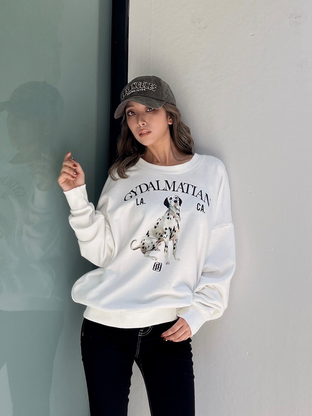 ホワイト系のスウェット、ブラック系のデニムパンツ、ホワイト系のブーツを着用したレディースの冬コーディネートの4枚目の写真