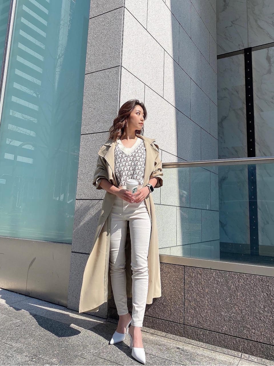 ベージュ系のトレンチコート、ホワイト系のデニムパンツ、ホワイト系のニット/セーターを着用したレディースの春コーディネートの4枚目の写真