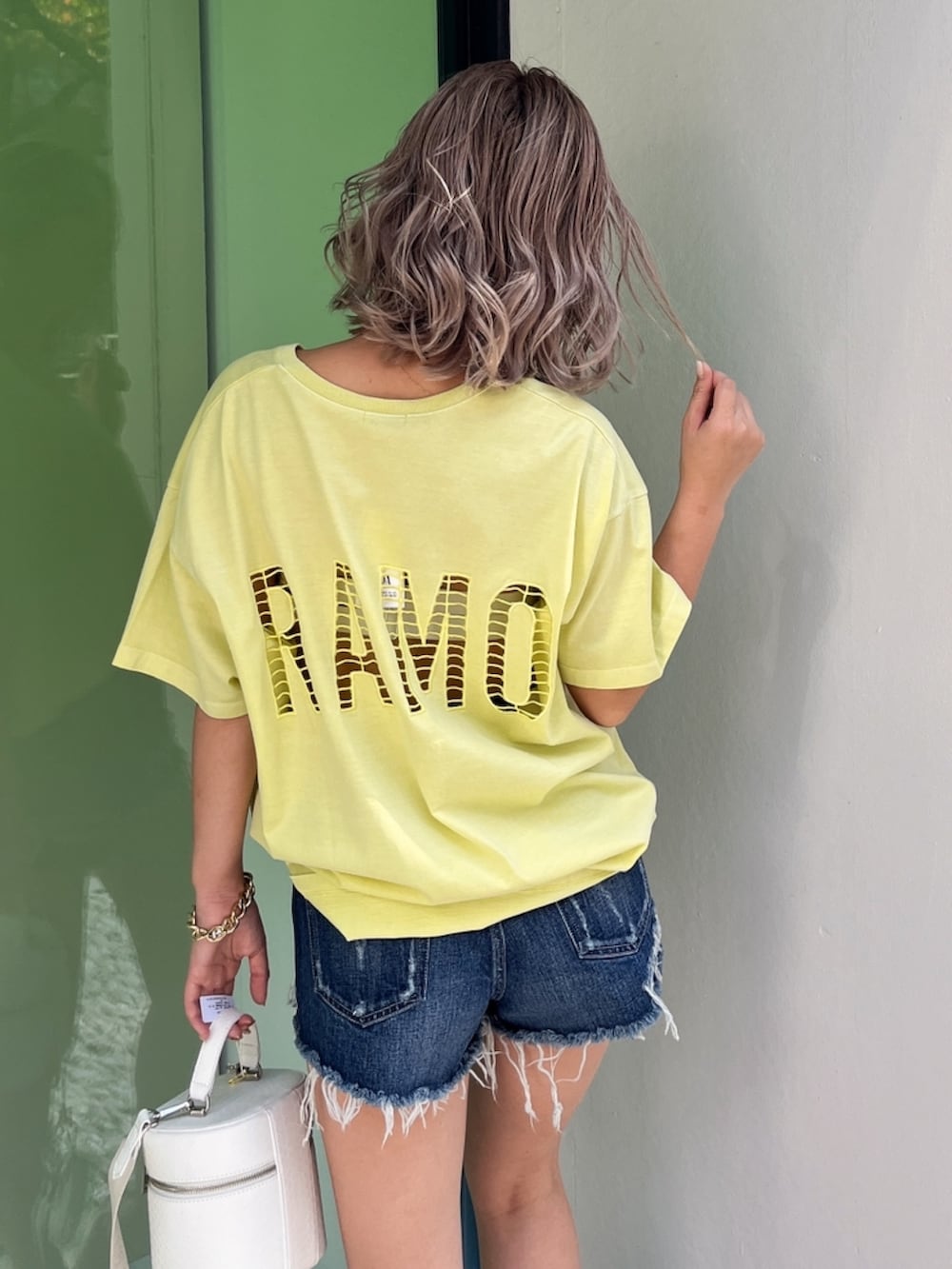 イエロー系のTシャツ/カットソー、ブルー系のデニムパンツ、ベージュ系のサンダルを着用したレディースの夏コーディネートの3枚目の写真