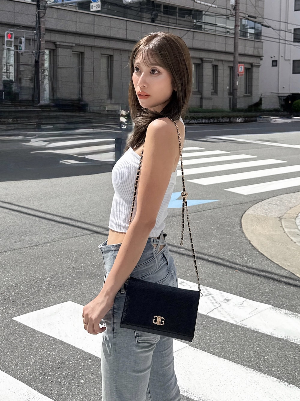 ホワイト系のタンクトップ、ブラック系のデニムパンツ、ブラック系のサンダルを着用したレディースの夏コーディネートの2枚目の写真
