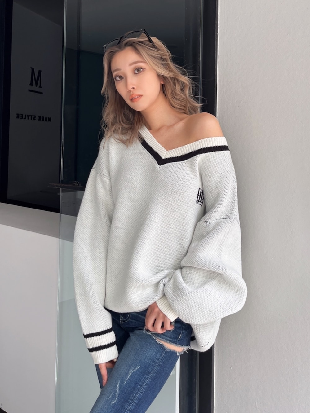 ブラック系のブーツ、ブルー系のデニムパンツ、ホワイト系のニット/セーターを着用したレディースの秋コーディネートの3枚目の写真