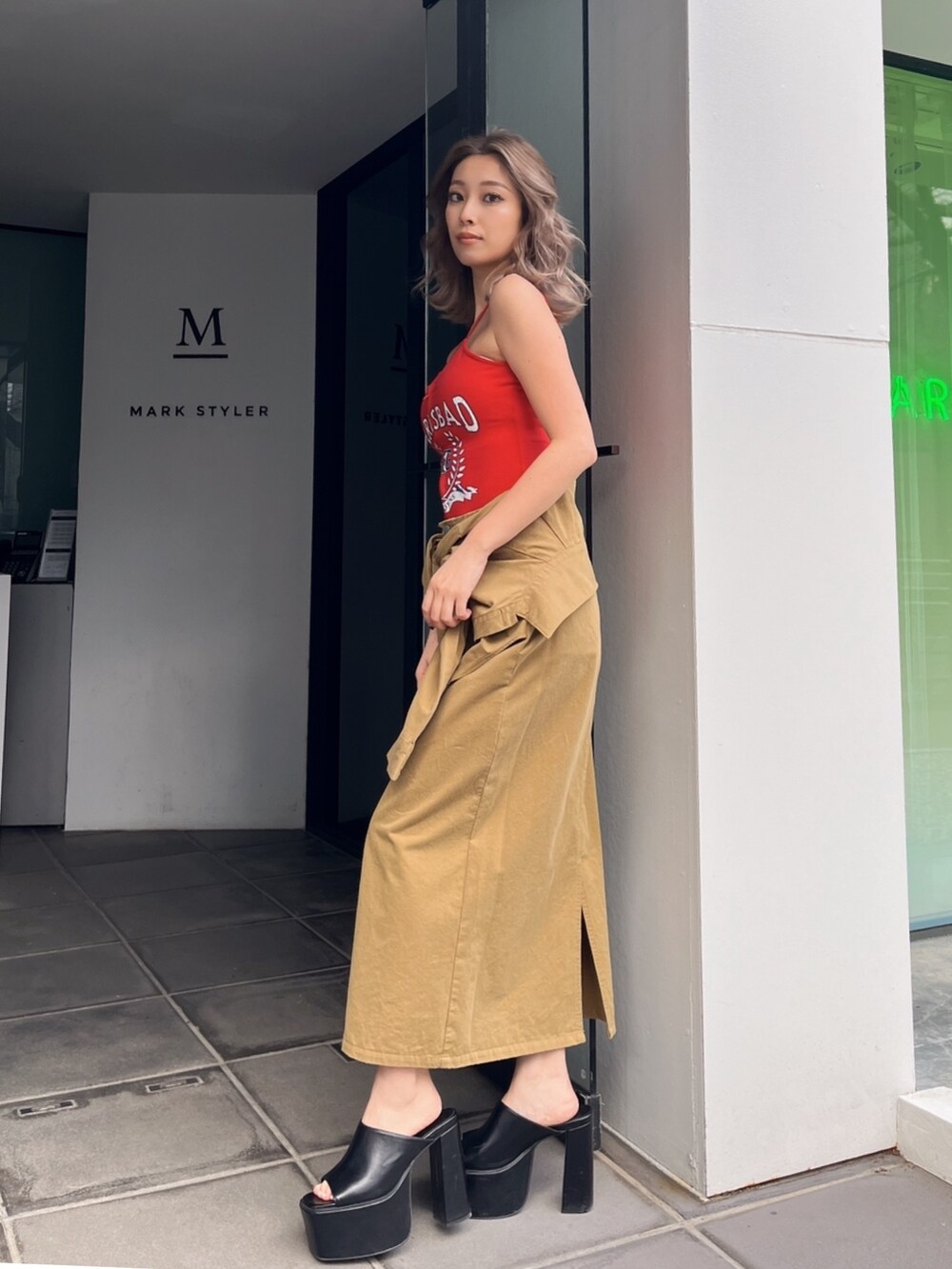 グリーン系のスカート、レッド系のキャミソール、ブラック系のサンダルを着用したレディースの夏コーディネートの2枚目の写真