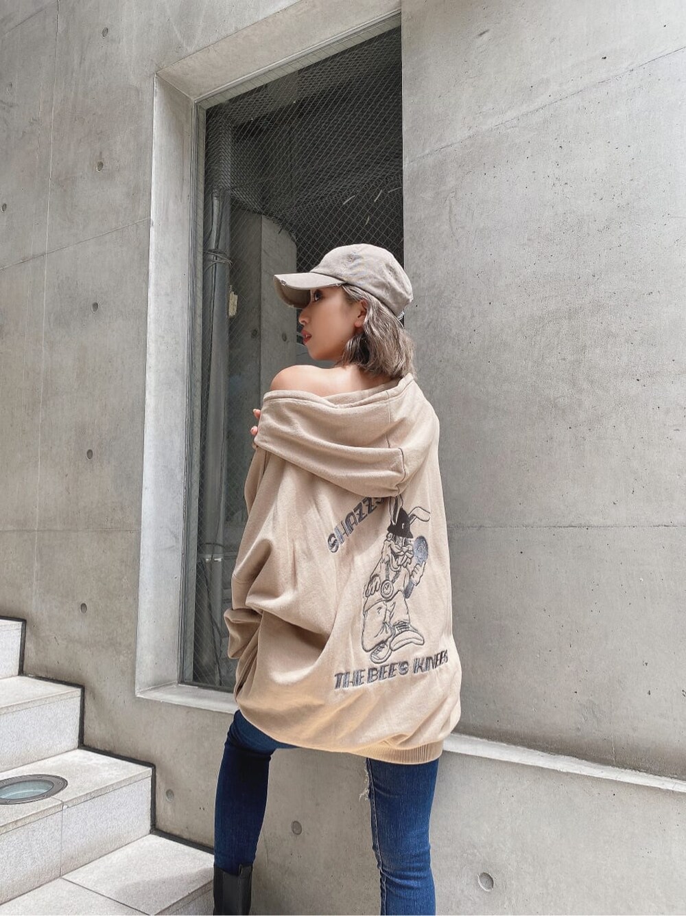 ブルー系のデニムパンツ、ベージュ系のパーカー、ベージュ系のキャップを着用したレディースの秋コーディネートの4枚目の写真