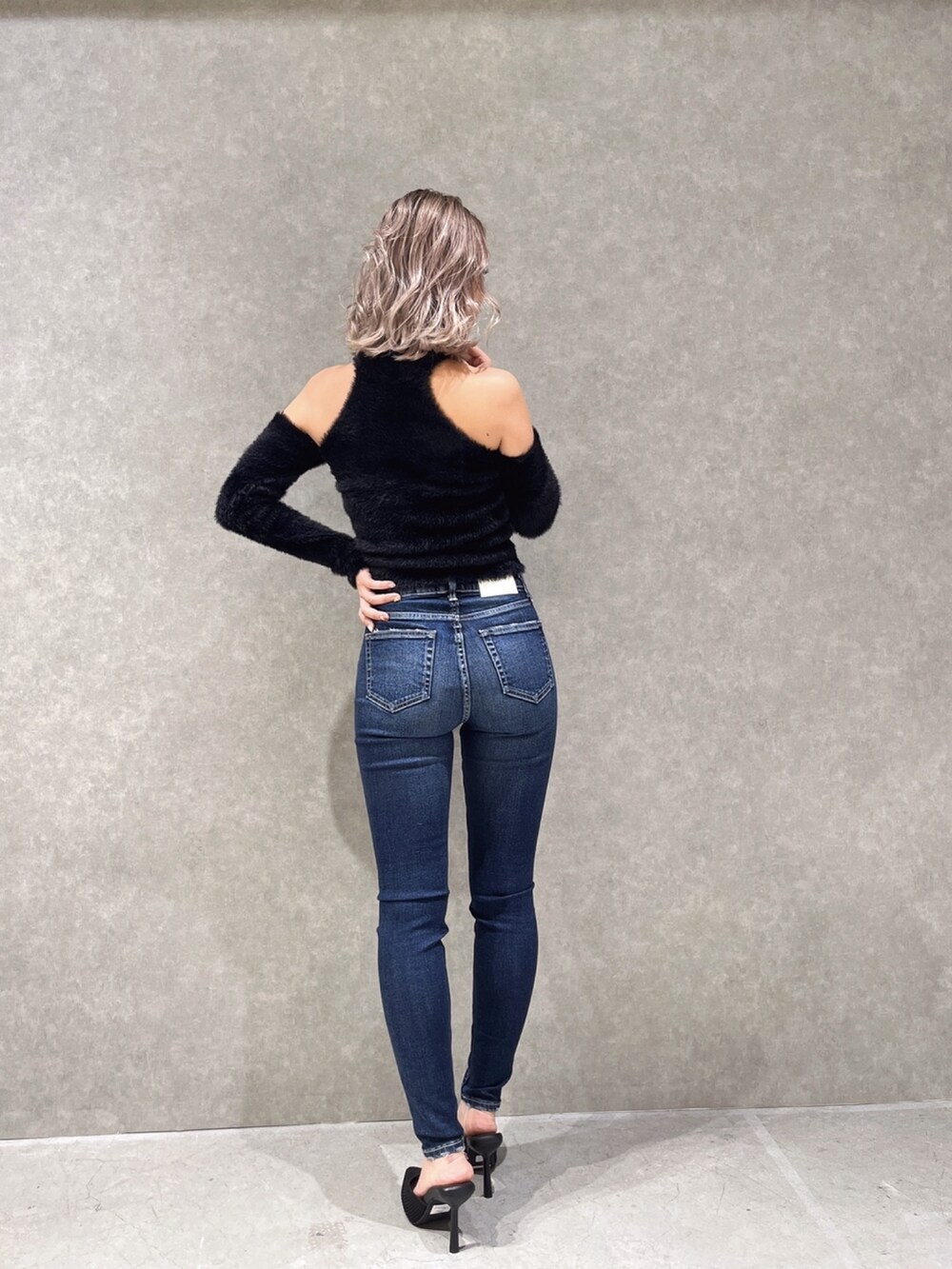 ブラック系のニット/セーター、ブルー系のデニムパンツを着用したレディースの冬コーディネートの2枚目の写真